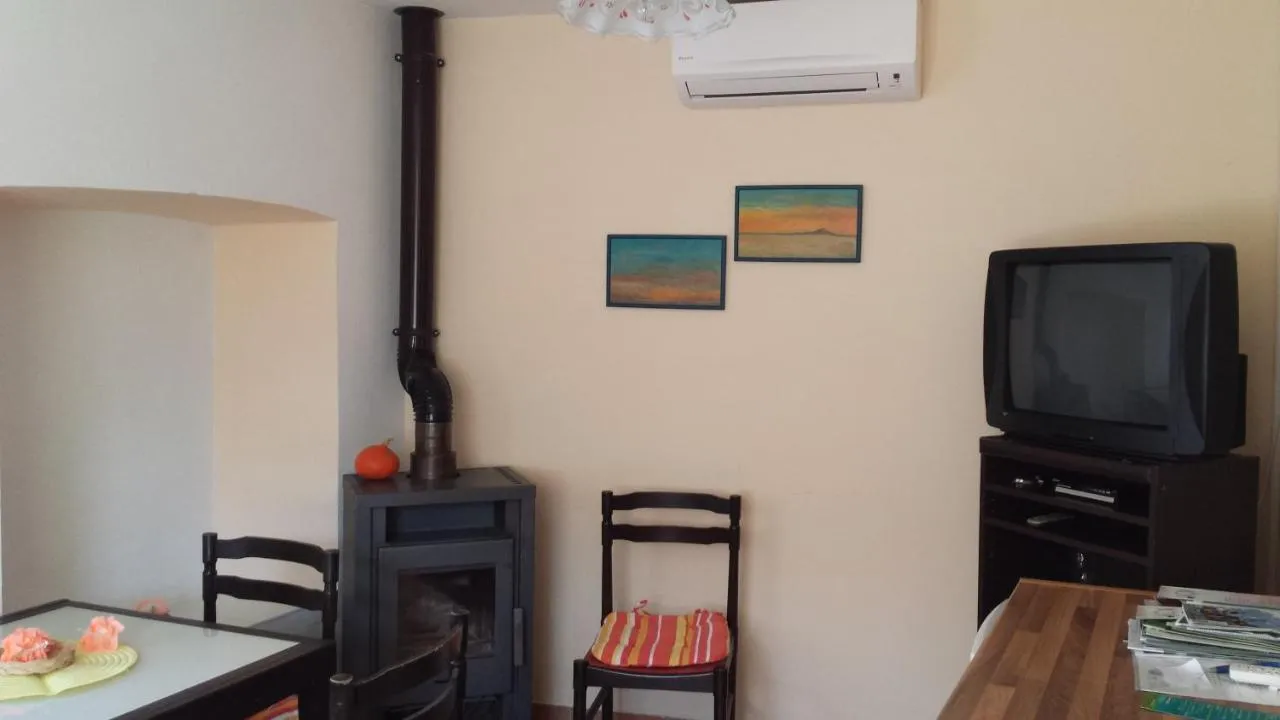 Dnevni prostor s pečjo na drva, klimo in televizorjem